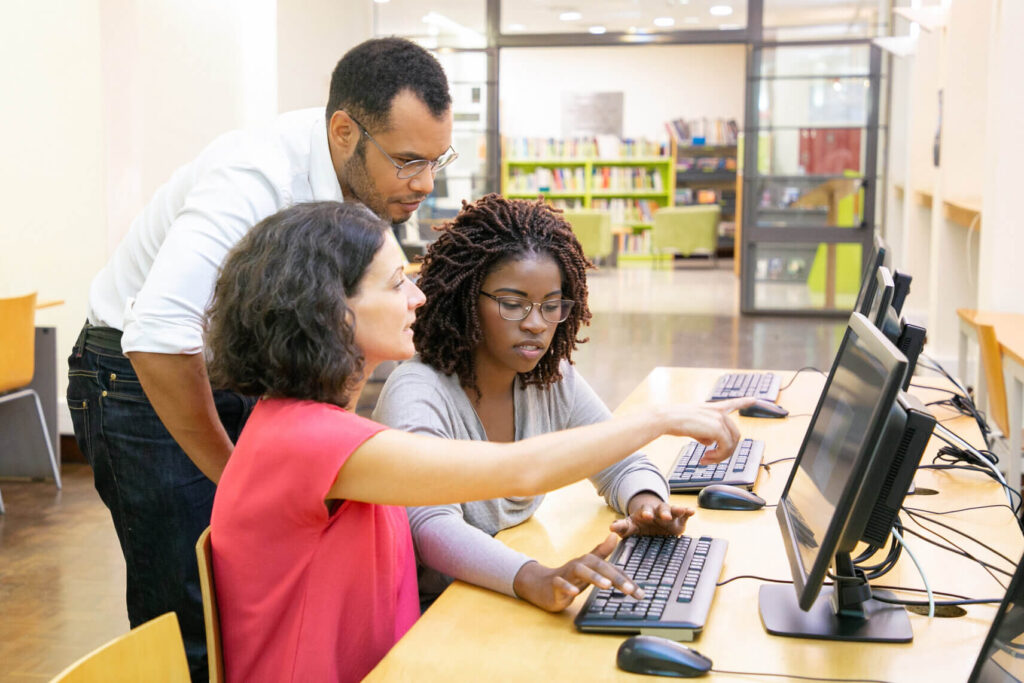 Education and job training programs represented by young adults learning in front of computers.