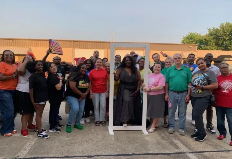 The Seasons of Change DFW Favorites 2026 team celebrating outdoors, featuring staff and community members smiling together around a large white photo frame.